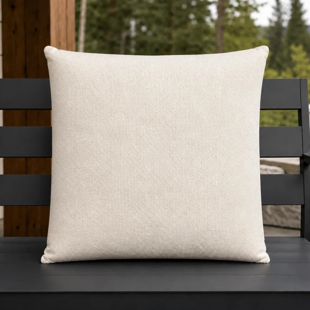 Ratana CU01218 ivory 18-inch square toss pillow on a charcoal outdoor bench.