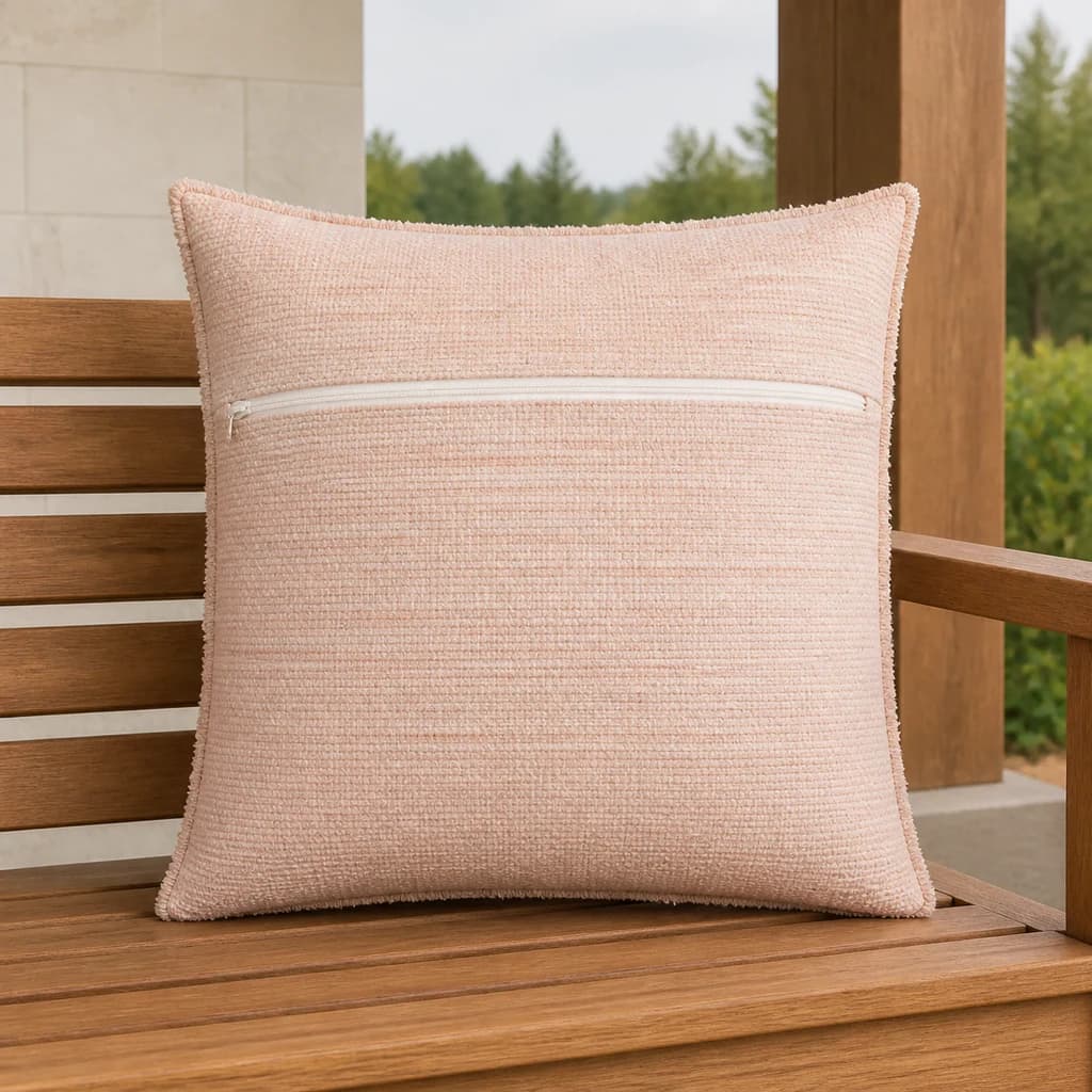 Ratana CU01316 Cova 16-inch blush toss pillow with zipper on a teak outdoor bench.