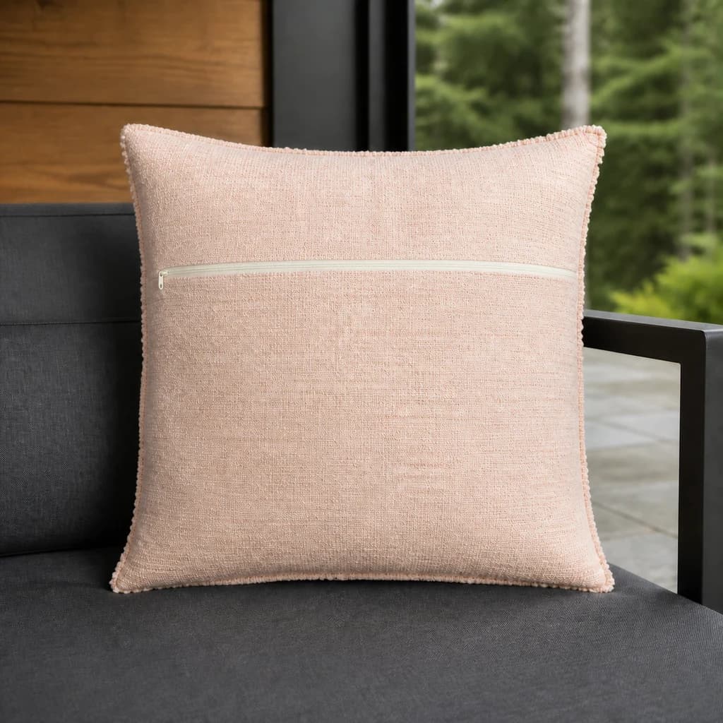 Ratana CU01318 Cova 18-inch blush toss pillow with zipper on a graphite outdoor lounge bench.