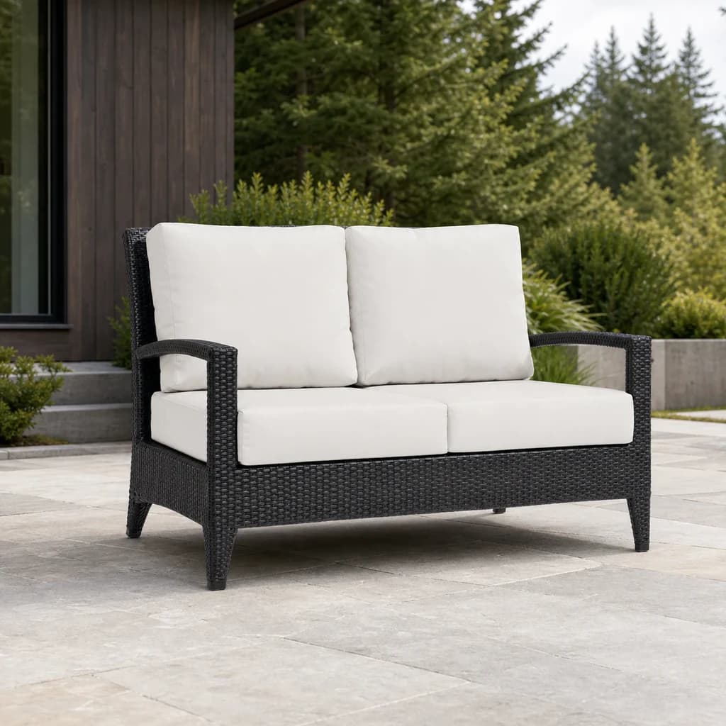 Ratana FN28302 New Miami Lakes Love Seat with four ivory cushions and dark woven frame on a stone patio.