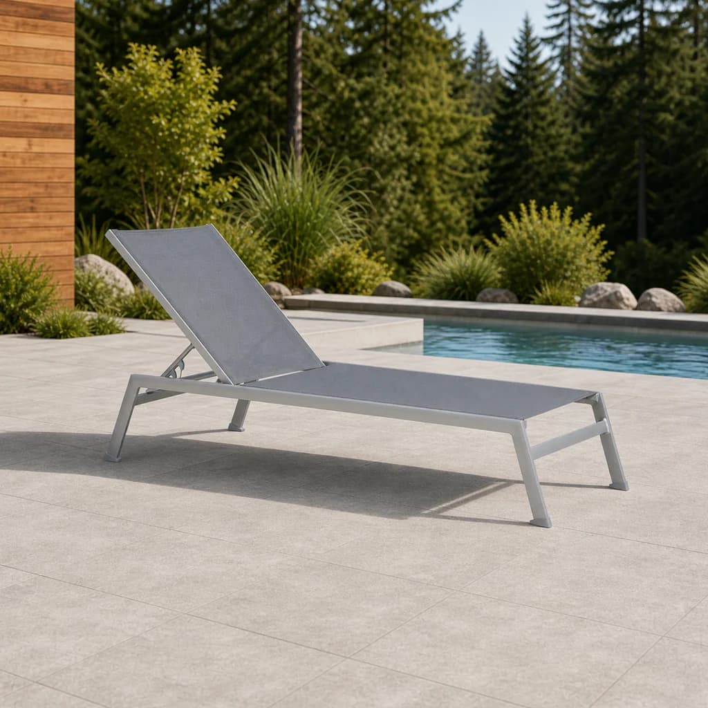 Ratana FN43520 Lucca adjustable Lounger with gray sling and silver frame beside a Pacific Northwest pool.