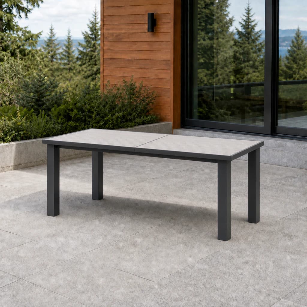 Ratana FN50482 Mezo closed extendable dining table with pale aluminum slat top and charcoal frame on a stone terrace.