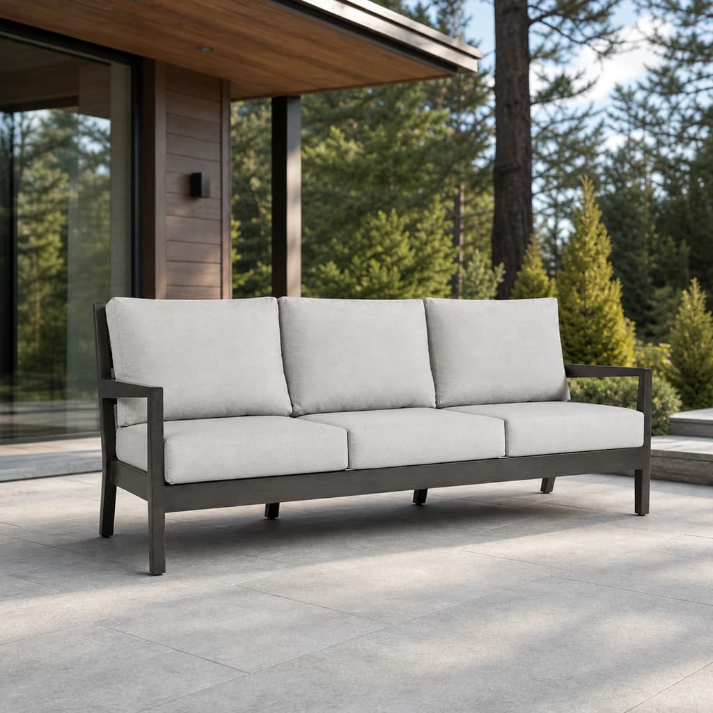 Ratana FN54403 Lucia Sofa with charcoal aluminum frame and six pale gray cushions on a premium outdoor terrace.