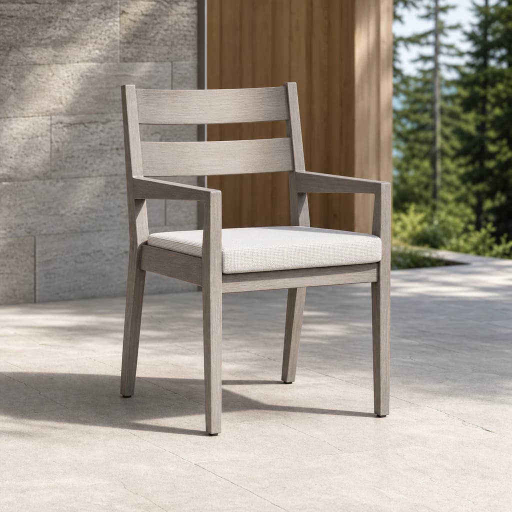 Ratana FN54412 Lucia Dining Arm Chair with pearl-gray aluminum frame and pale cushion on a stone terrace.