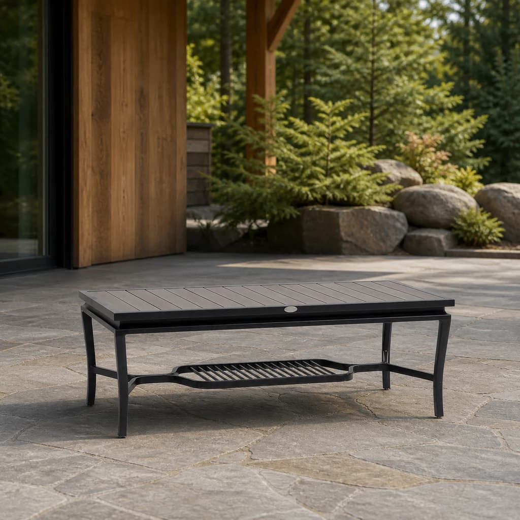 Ratana FN55004 Copacabana aluminum-top coffee table on an evergreen stone patio.
