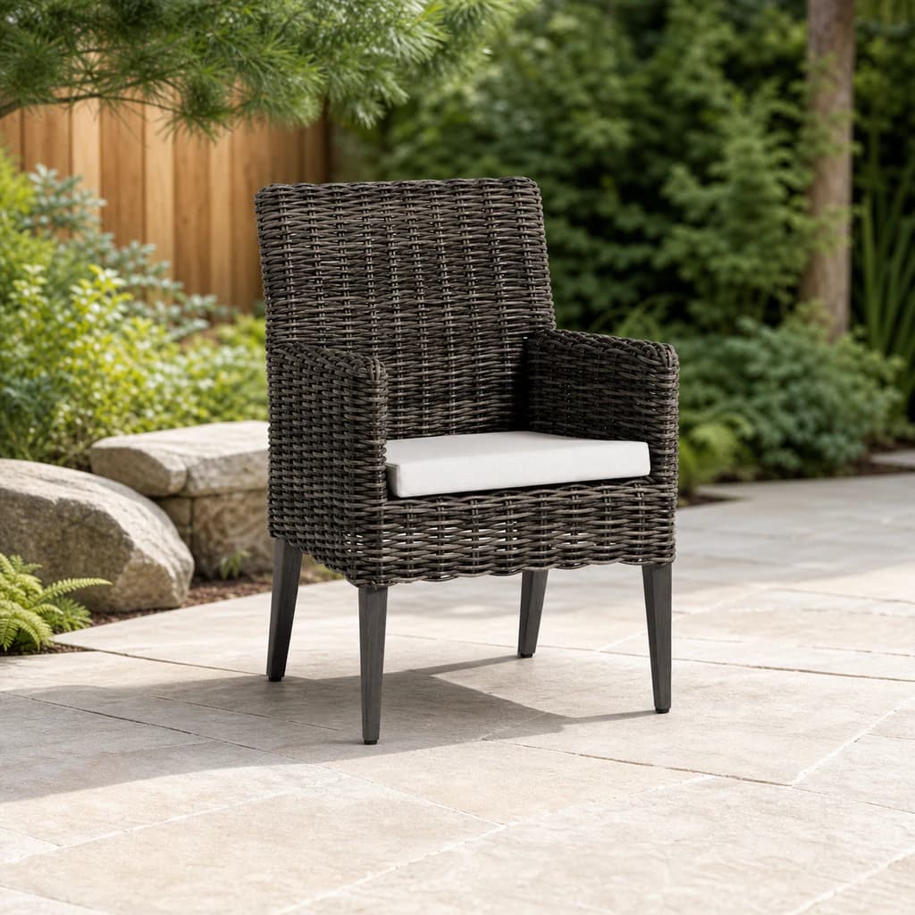 Ratana Cubo dark woven dining arm chair with one plain light cushion on a garden patio.
