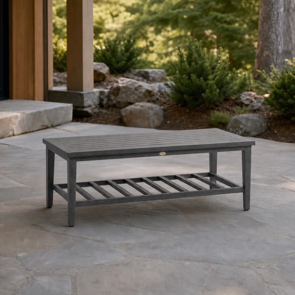 Ratana FN61704 Biltmore Coffee Table with charcoal slatted top and lower shelf on a stone patio.