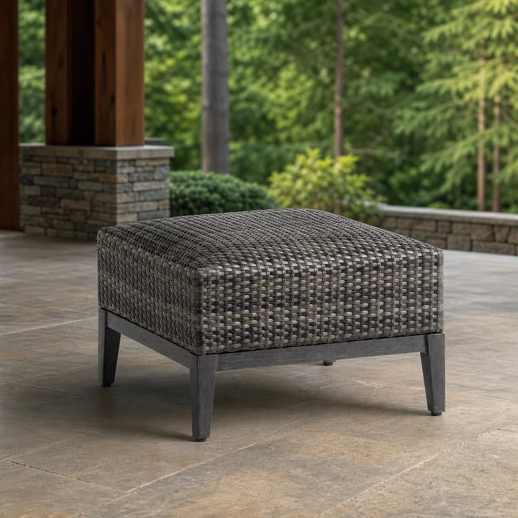 Ratana FN61716 Biltmore Ottoman with woven charcoal top and dark four-leg base on a stone patio.