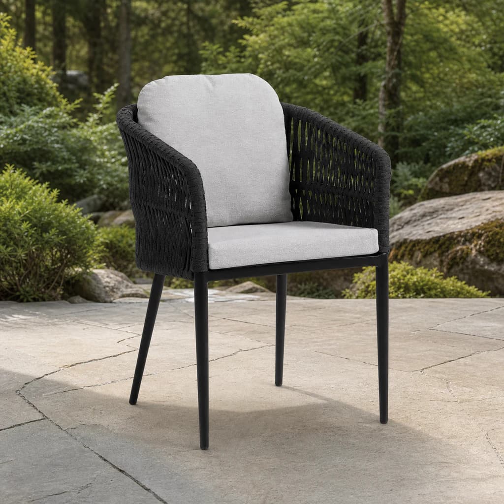 Ratana Gemelli black open-rope dining arm chair with plain light cushions on a garden patio.