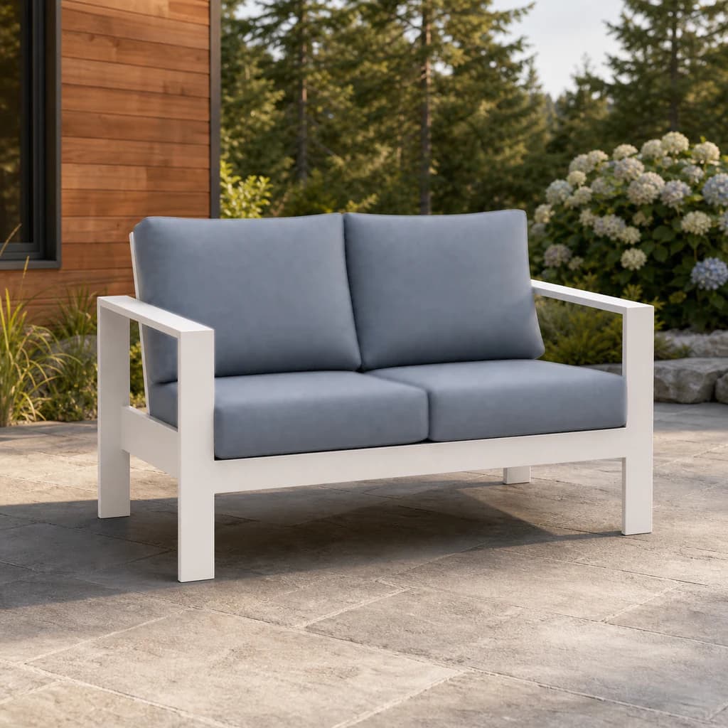 Ratana Vienna love seat with white aluminum frame and plain blue-gray cushions on a Pacific Northwest terrace.