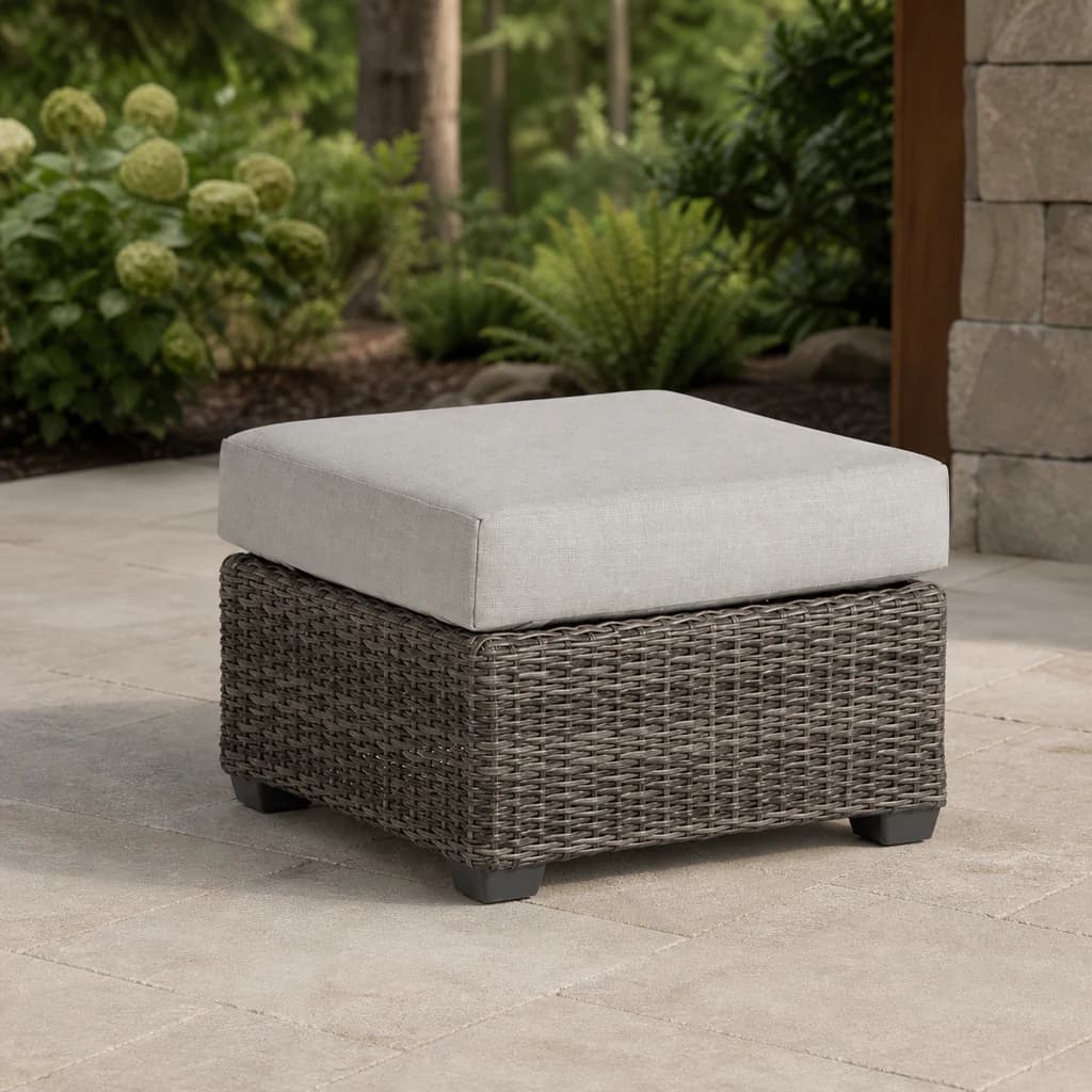 Ratana FN71216 Coral Gables ottoman with a pale cushion on a forest patio.